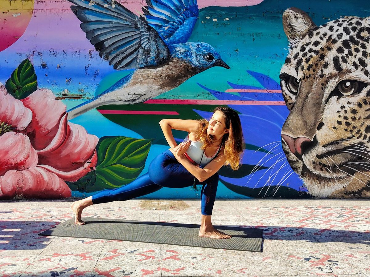 Natalia en postura de yoga frente a un mural en Barcelona